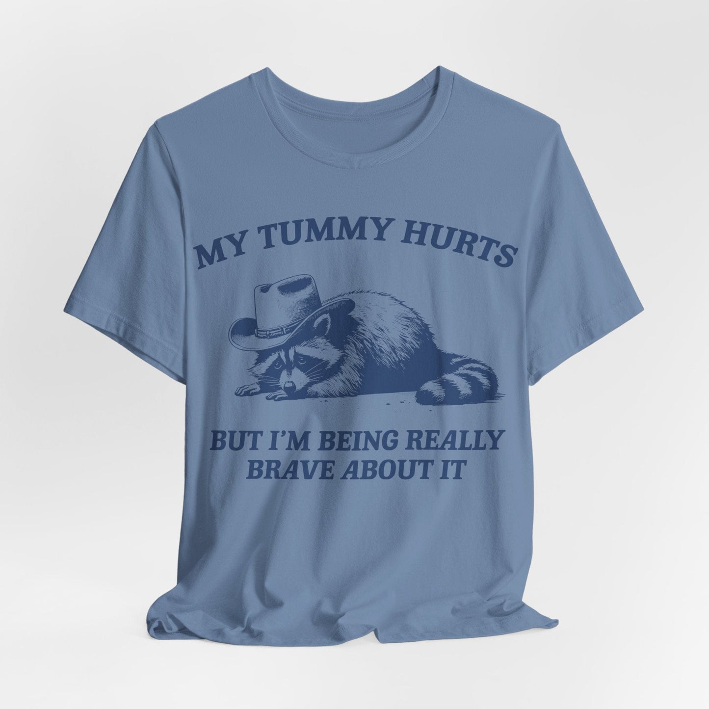 My Tummy Hurts But I’m Being Really Brave About It – Cowboy Raccoon Tee