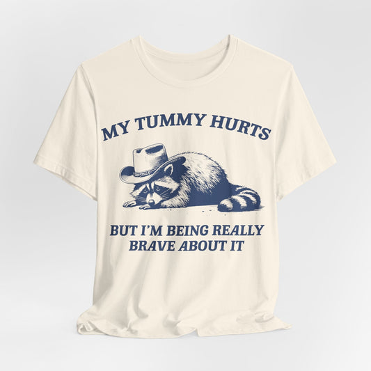 My Tummy Hurts But I’m Being Really Brave About It – Cowboy Raccoon Tee